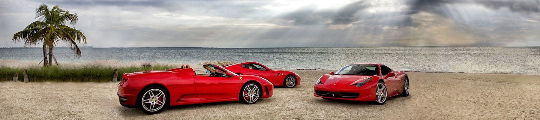 Three of our red Ferraris lined up on a beach