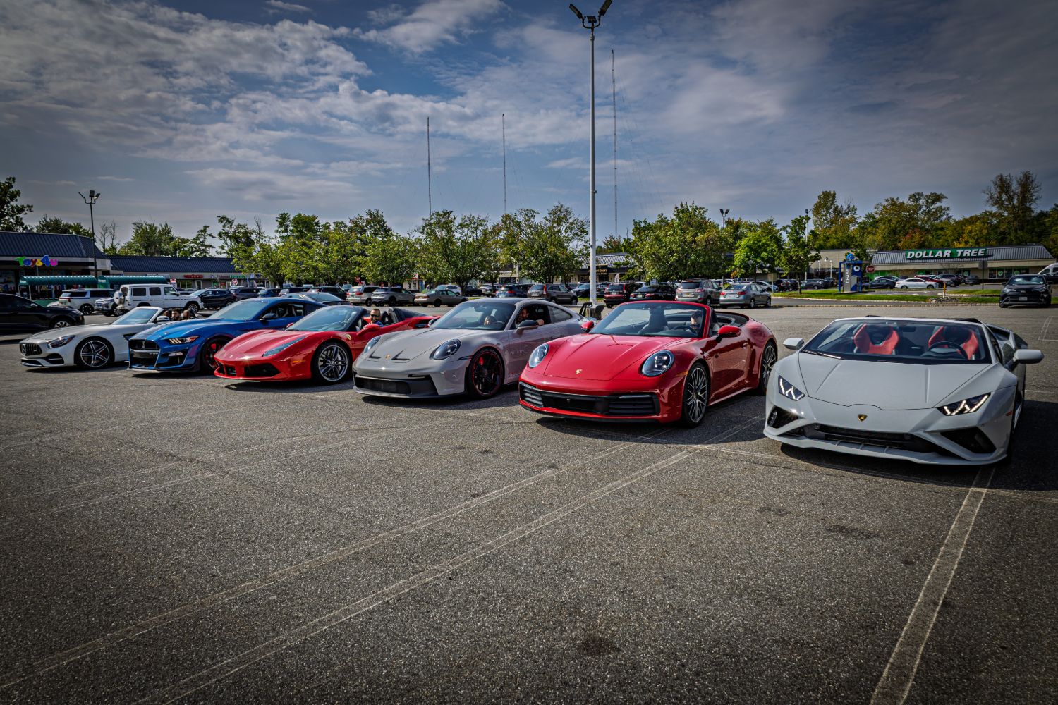 Six Dream Car Tour cars parked in a row — Mercedes-AMG GT, Shelby GT500, Ferrari 488 Spider, Porsche 911 GT3, 911 Cabriolet and Lamborghini Huracán Spyder